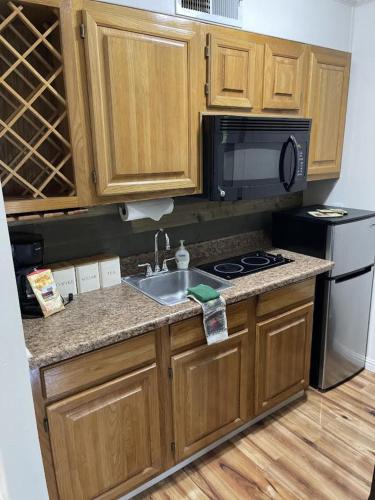 a kitchen with a sink and a stove and a microwave at Blue Spruce Condo #134 in Ruidoso