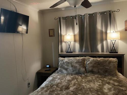 a bedroom with a bed with a ceiling fan and two lamps at Blue Spruce Condo #134 in Ruidoso