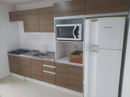 a kitchen with a white refrigerator and a microwave at Sobrado novo - Oktoberfest in Blumenau