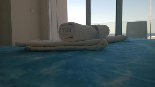 a couple of towels sitting on top of a bed at Clara Grace sea view in Leuca