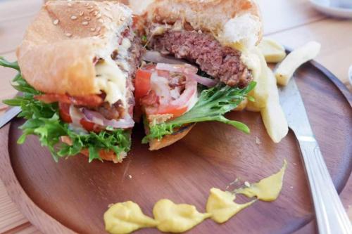 a sandwich cut in half on a plate with chips at Kata Beach Poshtel Phuket in Kata Beach