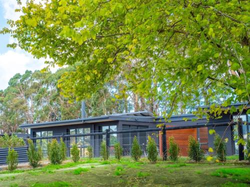a modern house with a fence in front of it at Gracie's Lane Villa 2 in Main Ridge