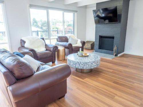 a living room with leather furniture and a fireplace at Gracie's Lane Villa 2 in Main Ridge