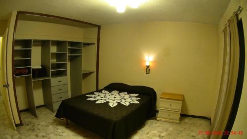 a bedroom with a bed and a dresser and a shelf at Hotel San Antonio Guanajuato in Guanajuato