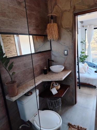 a bathroom with a toilet and a sink at Prana Cabaña Kira 3 hab in Samaipata