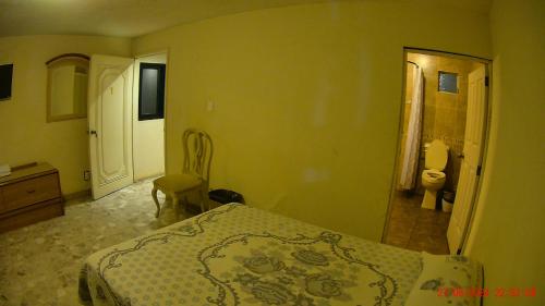 a bedroom with a bed and a bathroom with a toilet at Hotel San Antonio Guanajuato in Guanajuato
