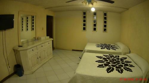 a bathroom with two beds and a sink and a mirror at Hotel San Antonio Guanajuato in Guanajuato