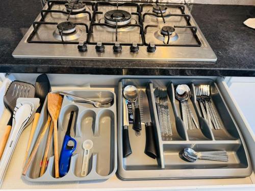a kitchen sink filled with utensils and a stove at 3 Bedroom Modern House in Luton LU4 0TY - Amazon Prime - No Party in Luton