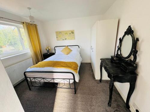 a bedroom with a bed and a mirror and a table at 3 Bedroom Modern House in Luton LU4 0TY - Amazon Prime - No Party in Luton