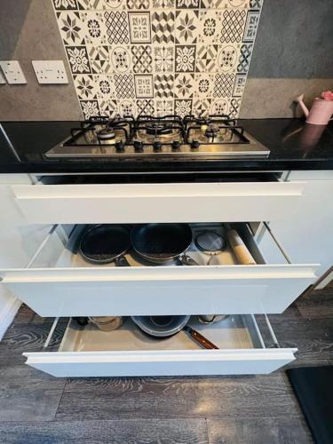an open refrigerator drawer filled with pots and pans at 3 Bedroom Modern House in Luton LU4 0TY - Amazon Prime - No Party in Luton