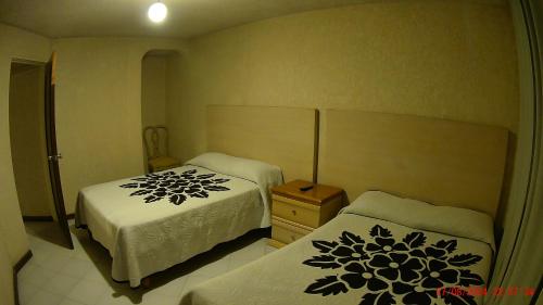 a small bedroom with two beds and a night stand at Hotel San Antonio Guanajuato in Guanajuato