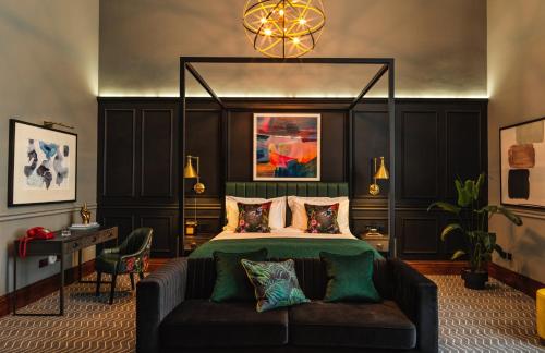 a bedroom with a bed and a couch in it at Kimpton Clocktower by IHG in Manchester