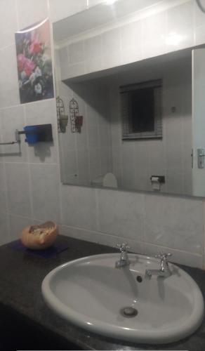 a bathroom with a white sink and a mirror at Garden View Guesthouse Fleurhof in Johannesburg
