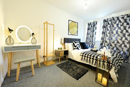 a bedroom with a bed with a mirror and a dressing table at Luton Airport House, Opposite airport staff parking in Luton