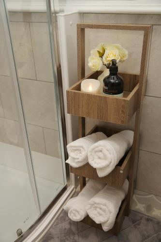 a towel rack with towels and a vase with flowers at Luton Airport House, Opposite airport staff parking in Luton