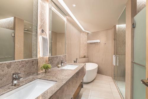 a bathroom with two sinks and a tub at Henann Premier Coast Resort in Panglao
