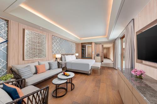 a living room with a couch and a television at Henann Premier Coast Resort in Panglao