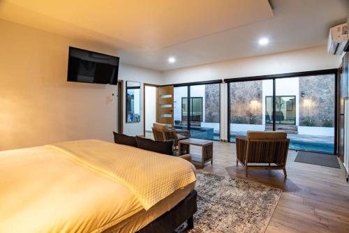 a bedroom with a large bed and a living room at Casa Samaria Valle de Guadalupe in Valle de Guadalupe