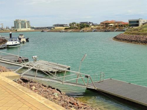a dock with a boat in a body of water at Gilmore Getaway in Wallaroo