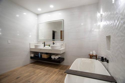 a white bathroom with two sinks and a tub at Casa Samaria Valle de Guadalupe in Valle de Guadalupe