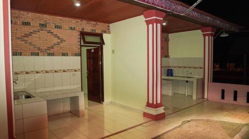 Una cocina con columnas rojas en una habitación. en Judita Cottages, en Tuk Tuk