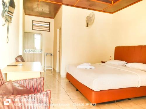 Un dormitorio con una cama, un escritorio y una silla. en Judita Cottages, en Tuk Tuk