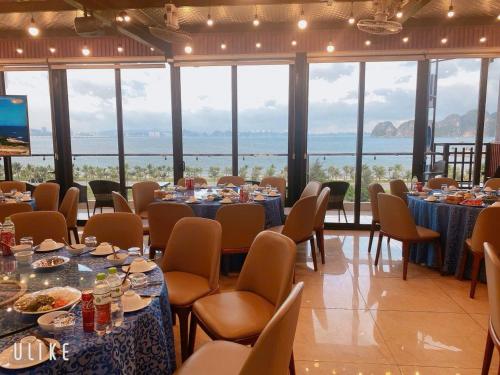 a dining room with tables and chairs with a view at Hạ Long Land Hotel in Ha Long
