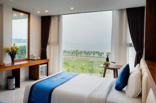 a bedroom with a bed and a large window at Hạ Long Land Hotel in Ha Long
