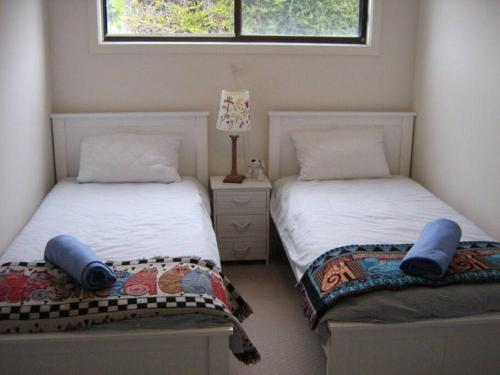 two beds sitting next to each other in a bedroom at St Helens Beachfront in Edithburgh