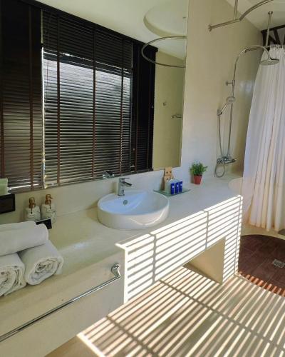 a bathroom with a sink and a mirror at Cae Villa Hua Hin in Hua Hin