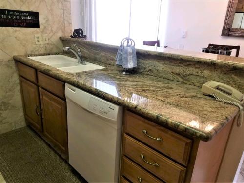 a kitchen counter with a sink and a dishwasher at Pinecliff Retreat in Ruidoso