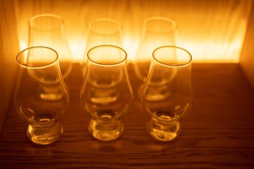 four empty wine glasses sitting on a table at Karuizawa Forest Seasons Villa in Karuizawa