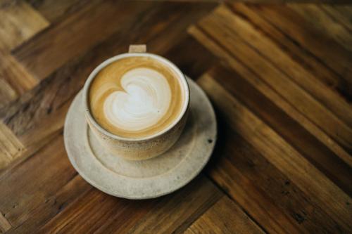 a cup of coffee on a plate on a table at Karuizawa Forest Seasons Villa in Karuizawa