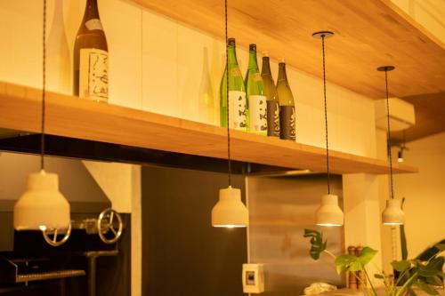 a row of wine bottles on a shelf in a kitchen at Karuizawa Forest Seasons Villa in Karuizawa