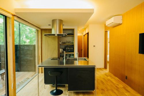 a kitchen with a black island with a sink at Karuizawa Forest Seasons Villa in Karuizawa