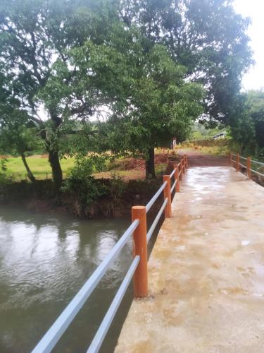 a bridge over a river with trees and water at Yashovana Nature Stay Gokarna in Gokarna