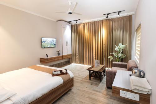 une chambre avec un lit et un salon avec un canapé dans l'établissement Rumuk Boutique Resort - Offbeat escape, à Dhanaulti