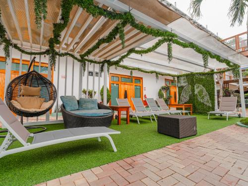 an outdoor patio with chairs and a swing at Blue Marlin Galápagos, Hotel & SPA in Puerto Baquerizo Moreno