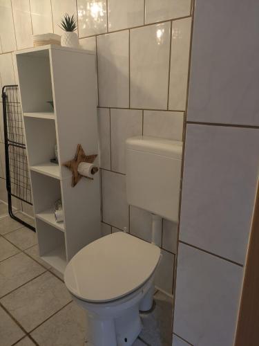 a bathroom with a white toilet in a room at Gemütlicher Glücksplatz in Frielendorf