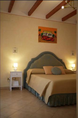 a bedroom with a bed and a night stand with a table at O Cannulicchiu in Altofonte