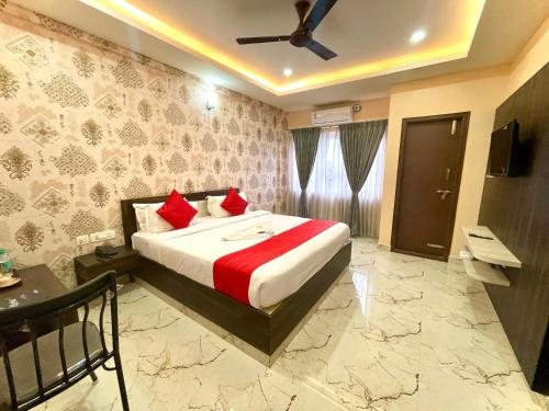 a bedroom with a large bed with red pillows at Aura By Agira Hotels in Yelahanka