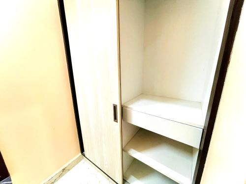 a small white refrigerator with a mirror in it at Aura By Agira Hotels in Yelahanka