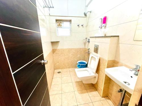a small bathroom with a toilet and a sink at Aura By Agira Hotels in Yelahanka