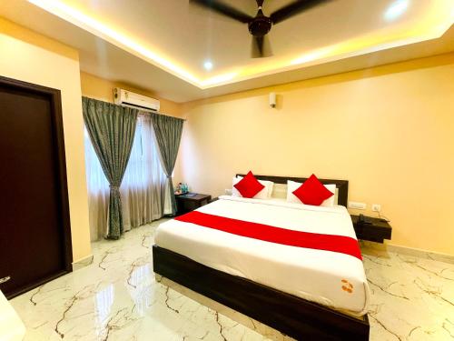 a bedroom with a large bed with red pillows at Aura By Agira Hotels in Yelahanka