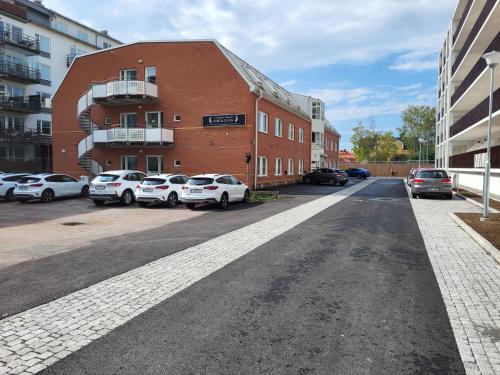 a street with cars parked in front of a brick building at Vandrarhem Uppsala - Portalgatan in Uppsala