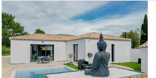 une statue assise devant une maison dans l'établissement Chambre privée dans villa récente, au Beausset