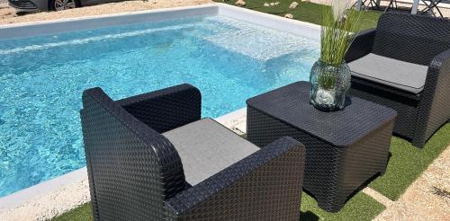 - une piscine avec 2 chaises, une table et un vase dans l'établissement Chambre privée dans villa récente, au Beausset