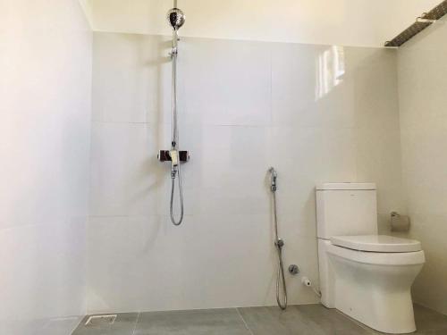 a bathroom with a shower with a toilet at Coastal Cloud Backpackers Villa in Unawatuna