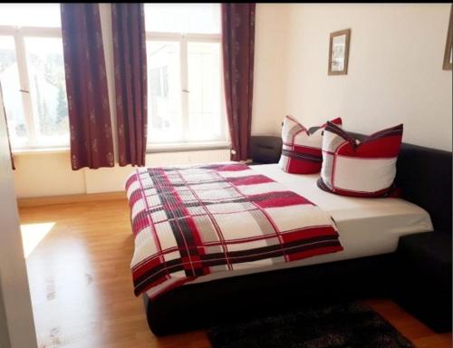 a bedroom with a bed with red and white pillows at Monteurwohnung, Arbeiterunterkunft, Pension, Gästewohnung in Altenburg , Kurz u Langzeitmiete in Altenburg