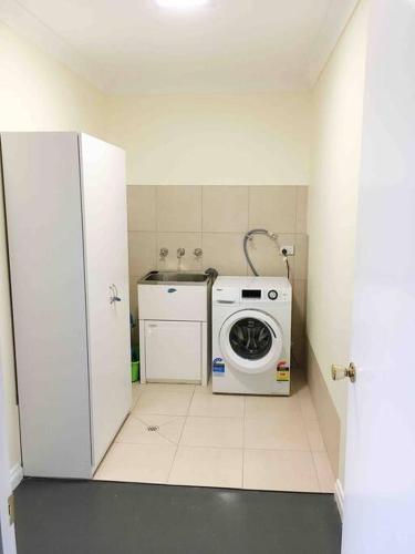 a small bathroom with a washing machine in it at Sea Valley Views in Port Lincoln